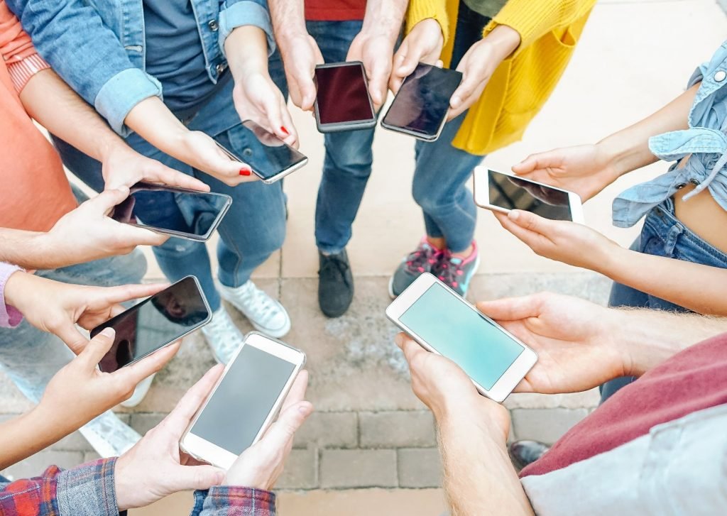 Work colleagues enjoy a smartphone team building activity outdoors