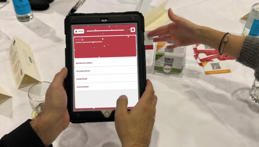 Personas disfrutando de una trivia navideña con tabletas en una cena festiva.