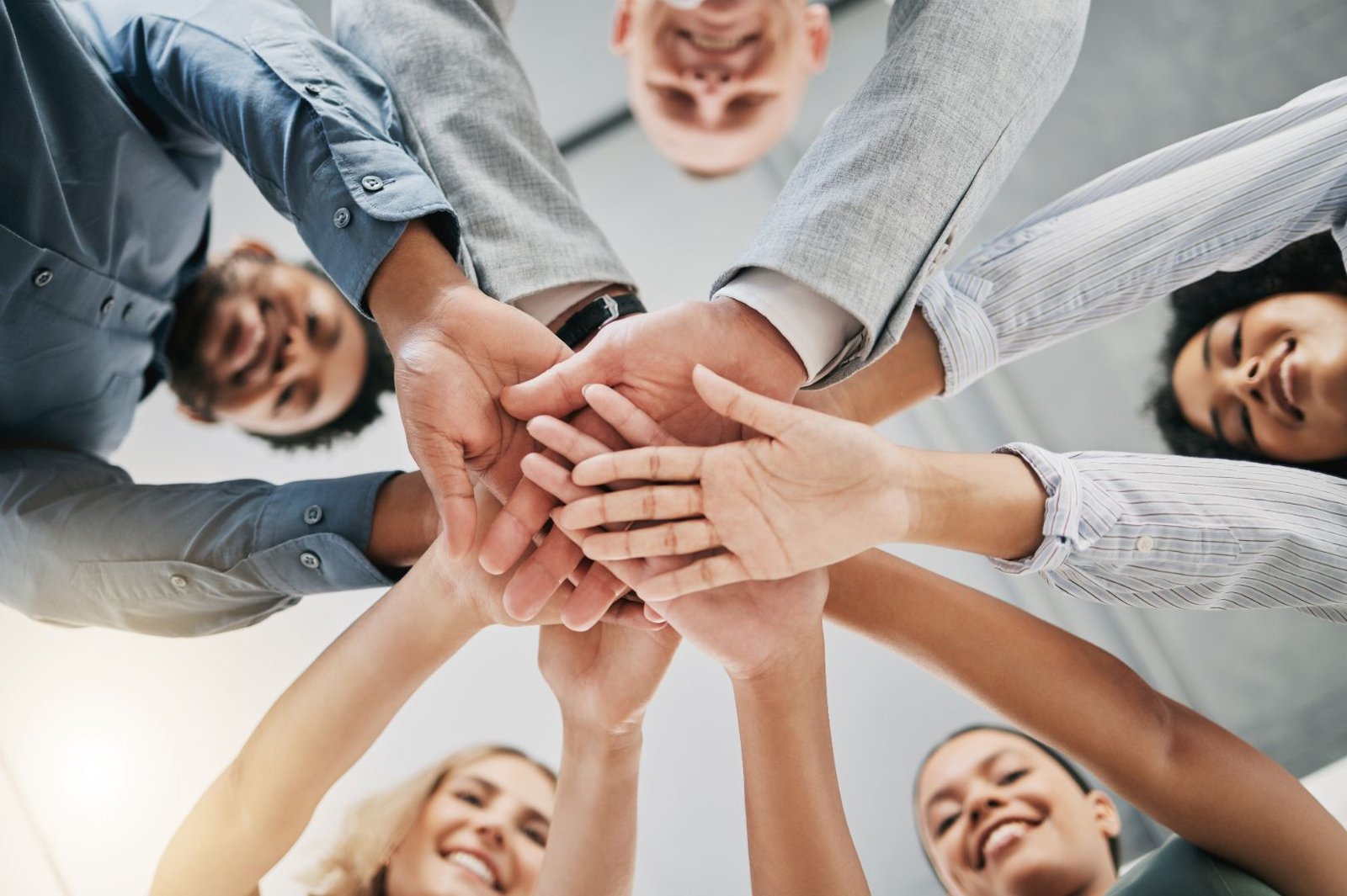 Group of people join hands in a team building activity