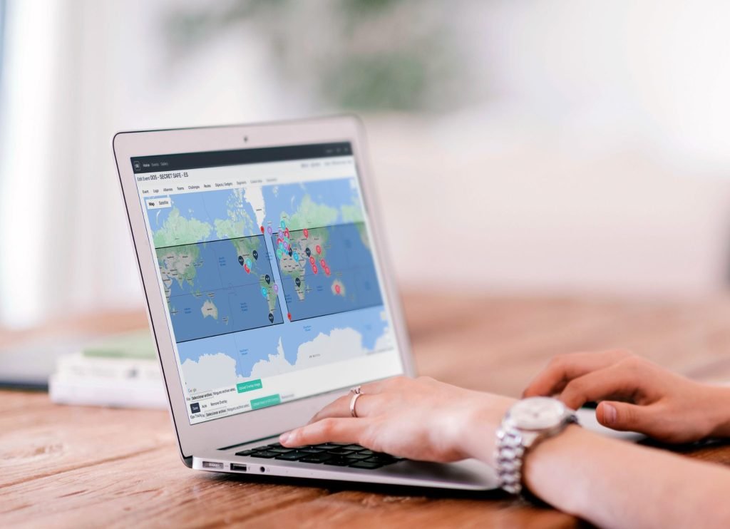person with a laptop looking at a map of the world 