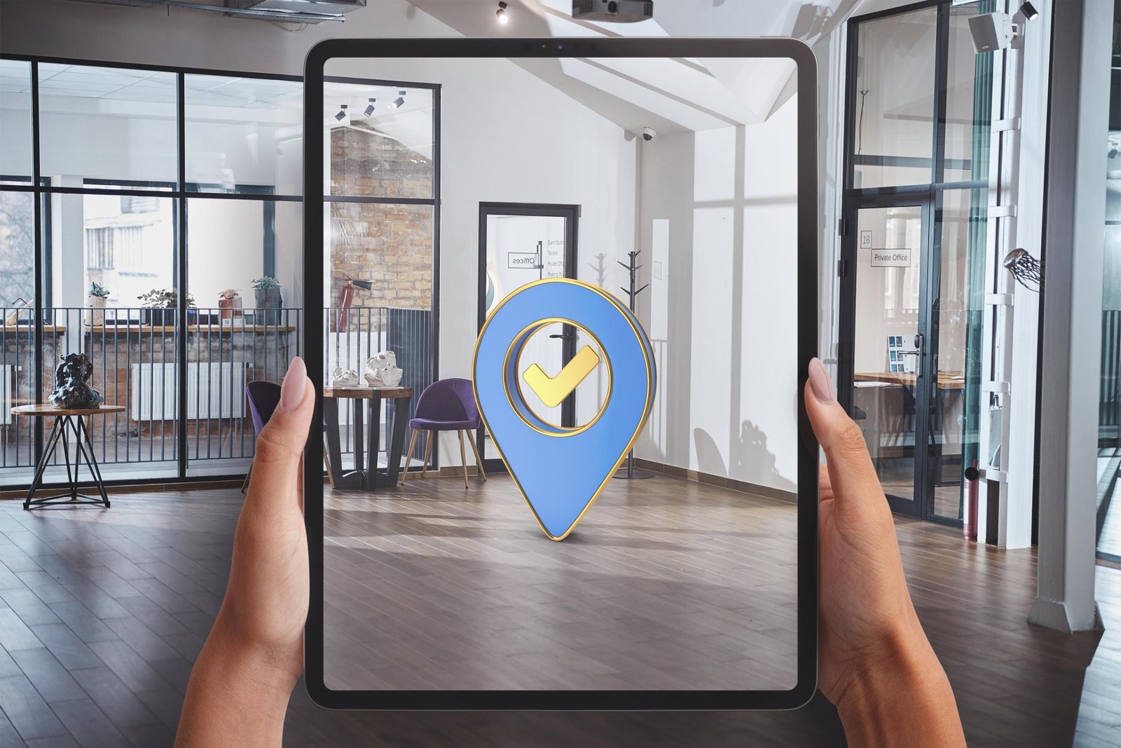 Person holding a tablet displaying augmented reality interface with a digital marker in an office setting.