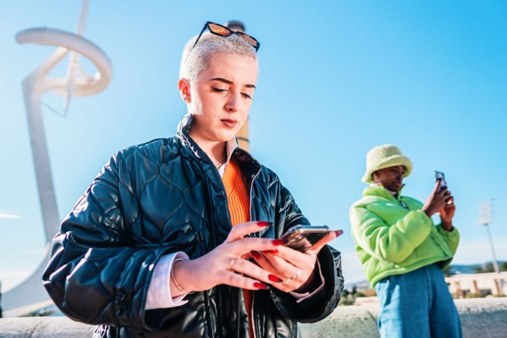 Participants using their smartphones during an outdoor, GPS-based team-building activity, interacting with a mobile app in a public urban space.